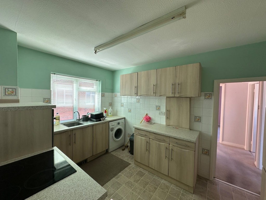 Lot: 6 - BALCONY FLAT OVERLOOKING DEVONSHIRE PARK TENNIS COURTS - Flat kitchen with cupboards and part tiled walls